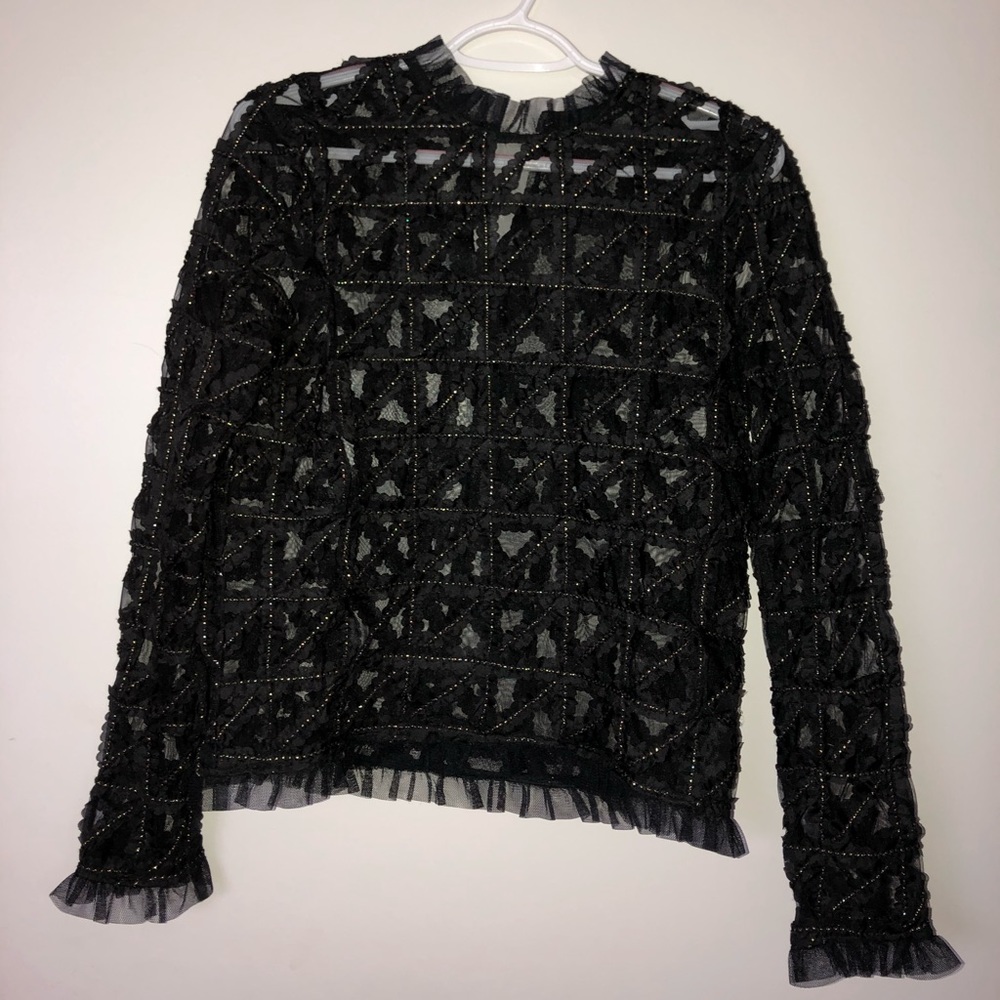 Black ruffled blouse detailed with gold